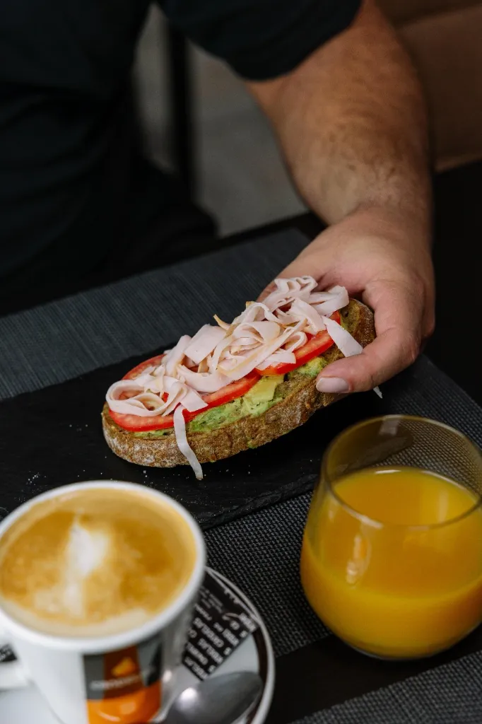 Tostada de aguacate con tomate y café para desayunar en El Bessó